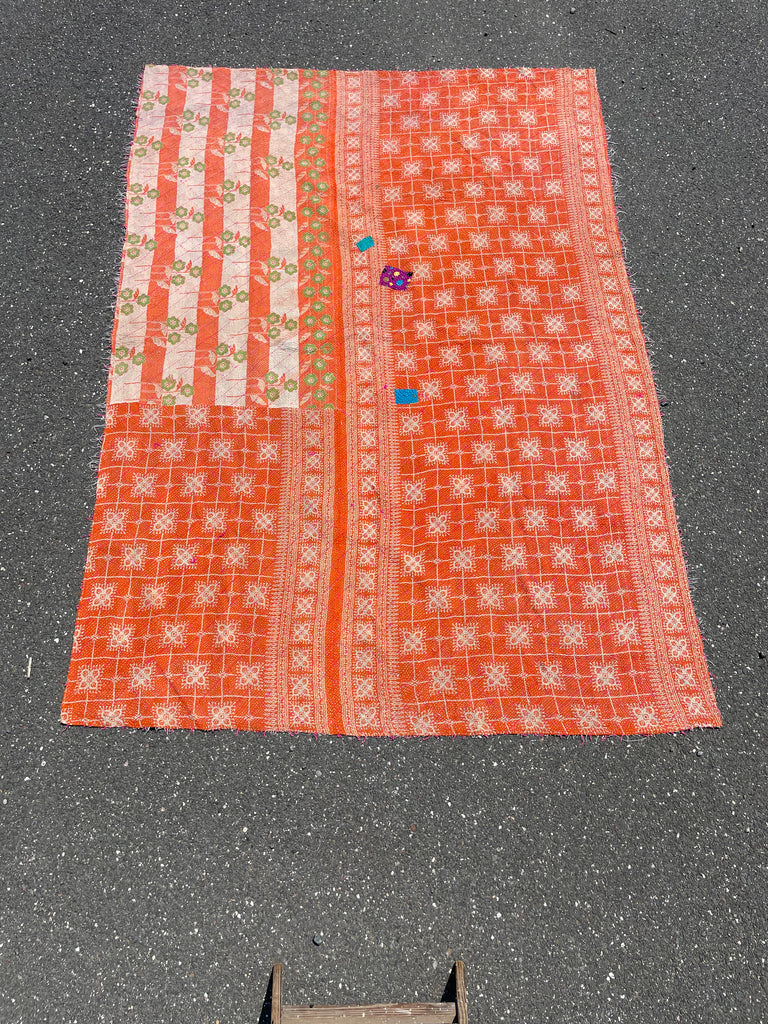 Textile with orange and white pattern on a dark surface