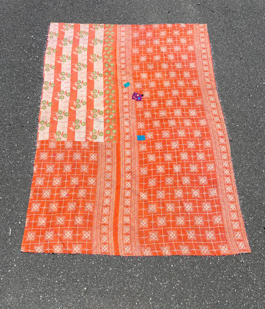 Textile with orange and white patterns on a gray surface