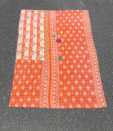 Textile with orange and white patterns on a gray surface