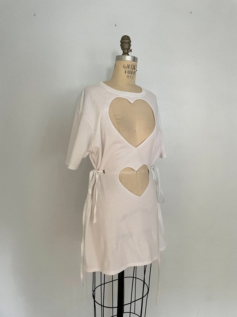 A white cotton t-shirt with double heart cut-outs and ties, displayed on a mannequin.