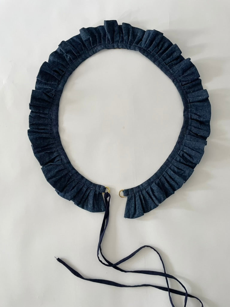 Dark blue ruffled belt on a light grey background