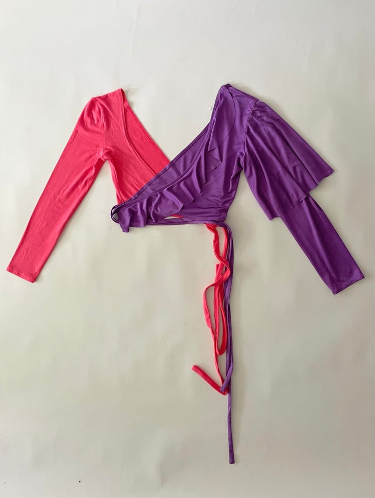 Pink and purple long-sleeve wrap top on a white background