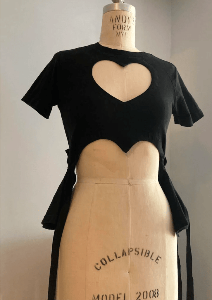 Fitted black heart cut-out T-shirt with tassels by Sarah Aphrodite, handmade from a repurposed cotton tshirt. Playful, sensual, and one-of-a-kind sustainable fashion.