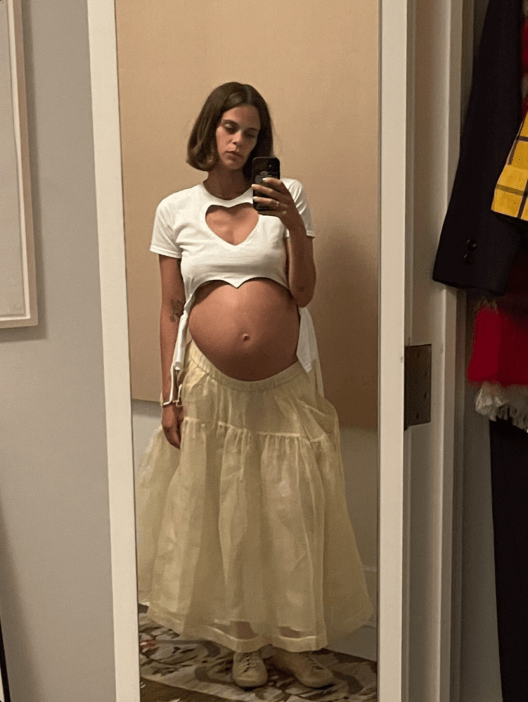 Fitted white heart cut-out T-shirt with tassels by Sarah Aphrodite, handmade from a repurposed cotton tshirt. Playful, sensual, and one-of-a-kind sustainable fashion perfect for maternity wear