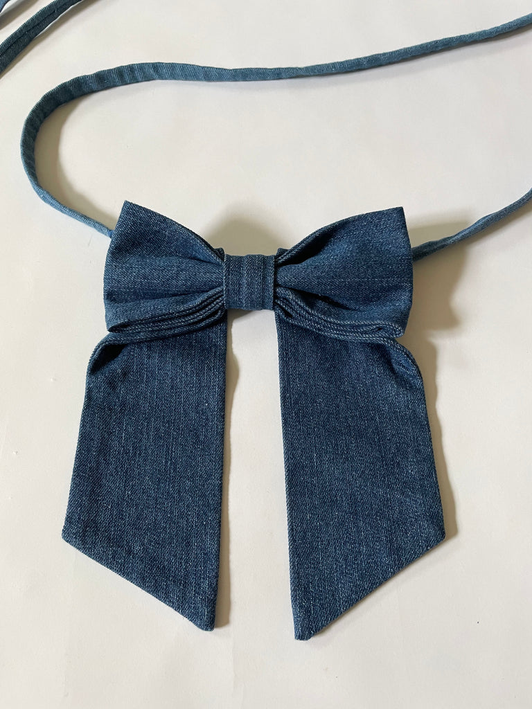 Handmade one-of-a-kind dark blue denim bow garter by Sarah Aphrodite, made from repurposed denim scraps, with long ties for versatile styling on arm, thigh, or waist.