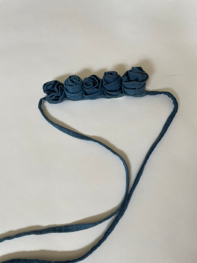 Handmade one-of-a-kind denim rose belt by Sarah Aphrodite. Crafted from repurposed denim scraps, sustainable and unique, versatile to wear around waist, shoulder, leg, arm, or ankle.