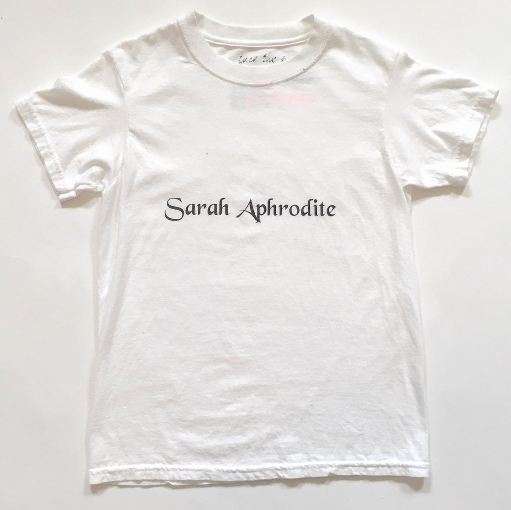 Handmade Sarah Aphrodite logo t-shirt, crafted from salvaged white cotton. Features screen-printed logo, natural markings from upcycled fabric, and a soft comfortable fit.