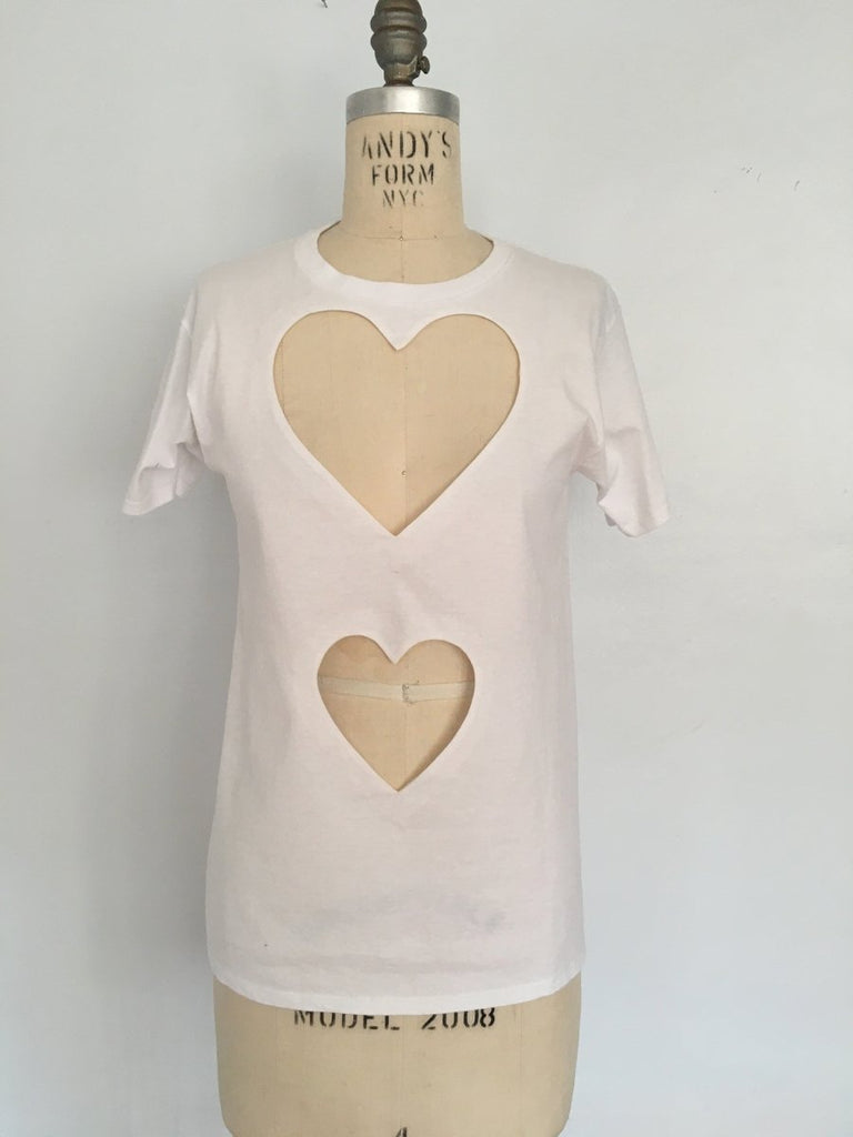 Fitted double heart cut-out t-shirt by Sarah Aphrodite, handmade from repurposed black or white cotton. Features two hand-cut heart openings, unique markings, and a fitted silhouette for layering or wearing solo.