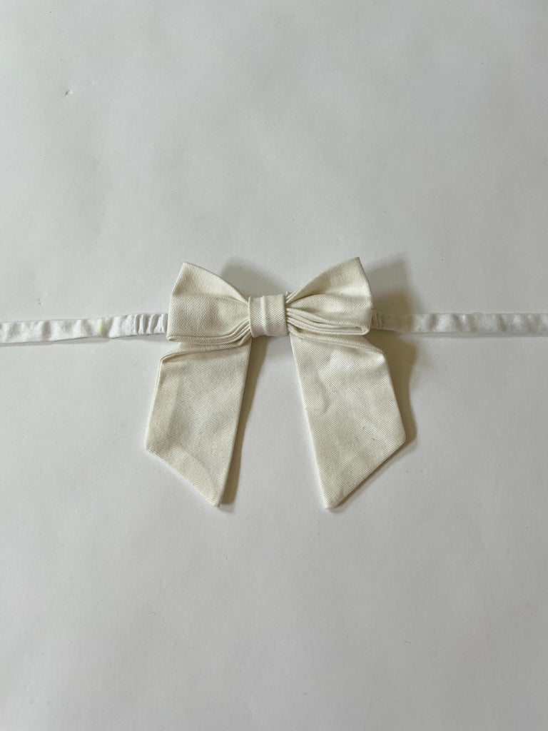 Handmade 4-inch bow accessory by Sarah Aphrodite with elastic ties, styled on ankle — each bow is one of a kind and made from repurposed fabric.